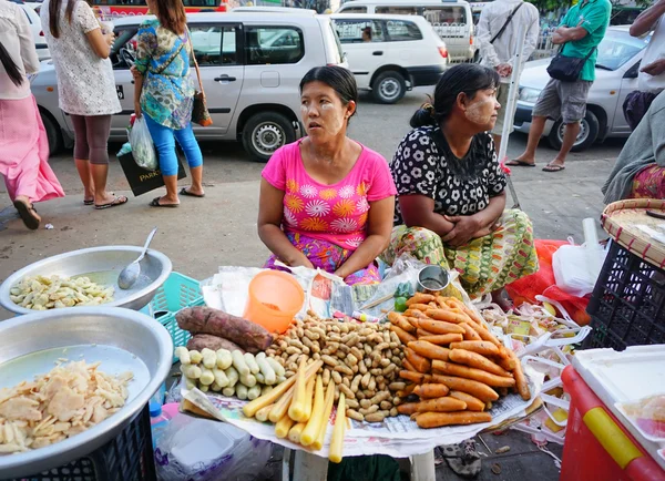 Burmese women selling sweet cakes in the market