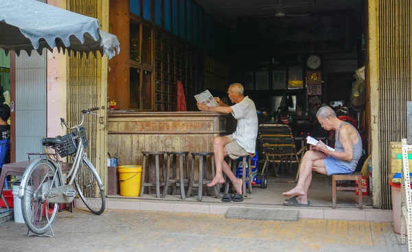 Elderly Chinese men reading newspaper