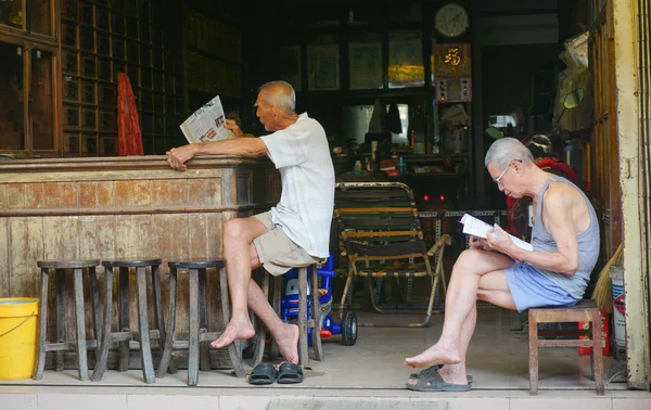 Elderly Chinese men reading newspaper