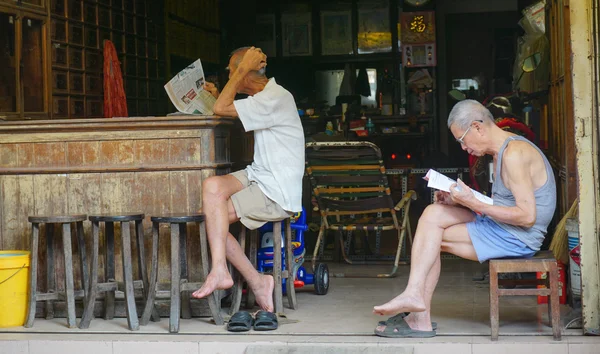 Elderly Chinese men reading newspaper