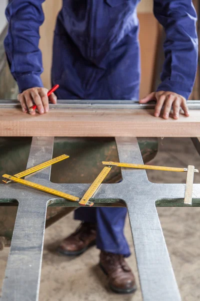 Carpenter marking a plank