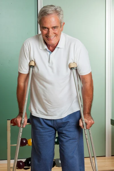 Elder man using a crutches