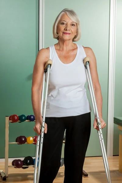 Woman with a neck brace using crutches