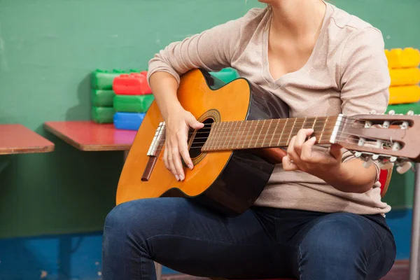 Music teacher playing guitar