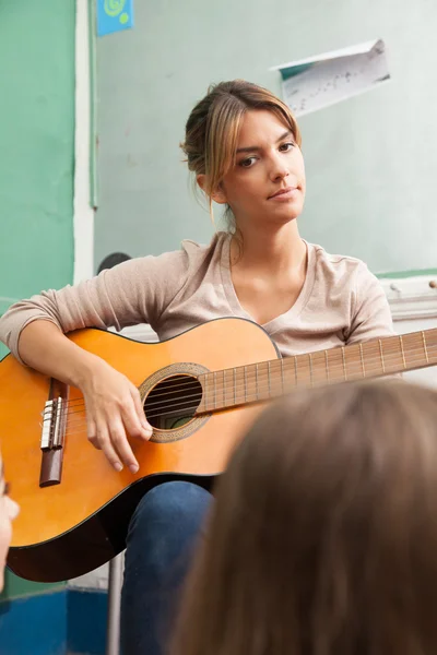 Music teacher playing guitar