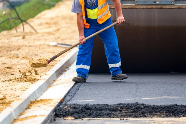 The workers and the asphalting machines