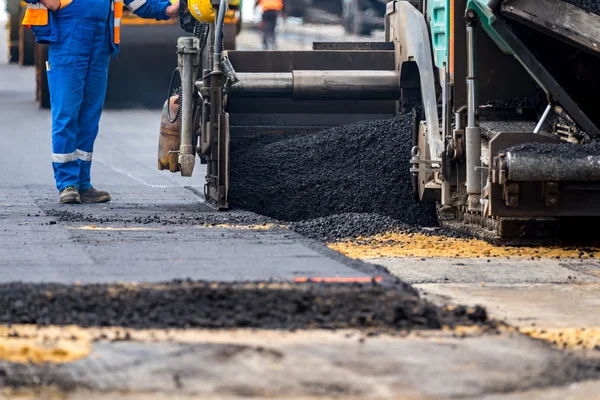 The workers and the asphalting machines