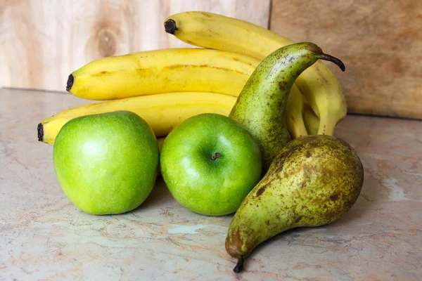 Still life. A bunch of ripe bananas, green apples and pears Conference