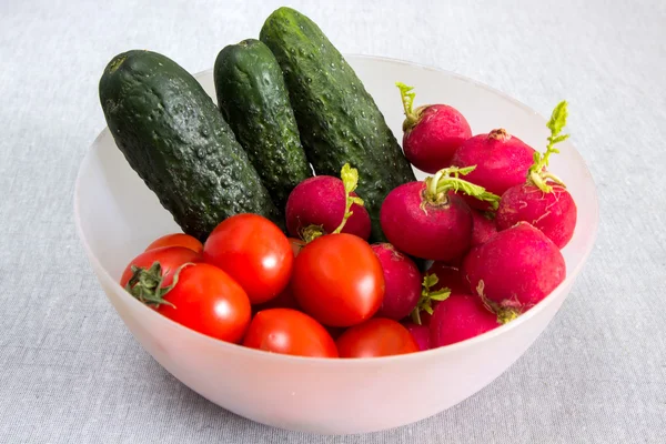 A bowl with vegetables. Radishes, cherry tomatoes, cucumbers