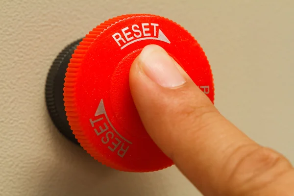 Finger touch on red emergency stop switch