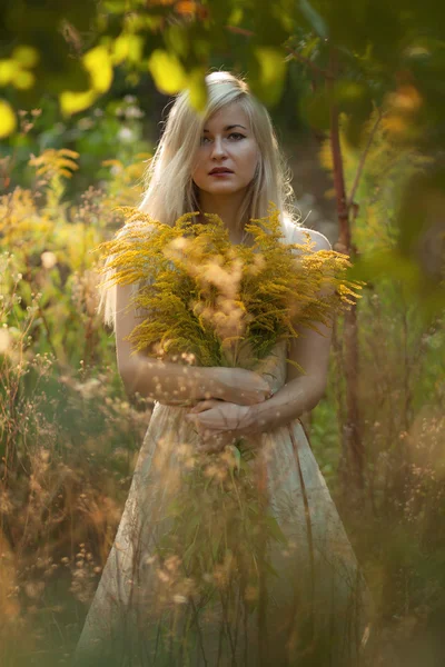 Beautiful young woman in white dress with long snow-white hair o