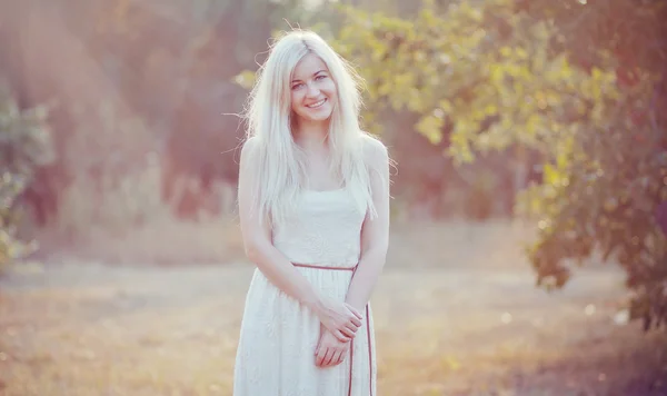 Beautiful young woman in white dress with long snow-white hair o
