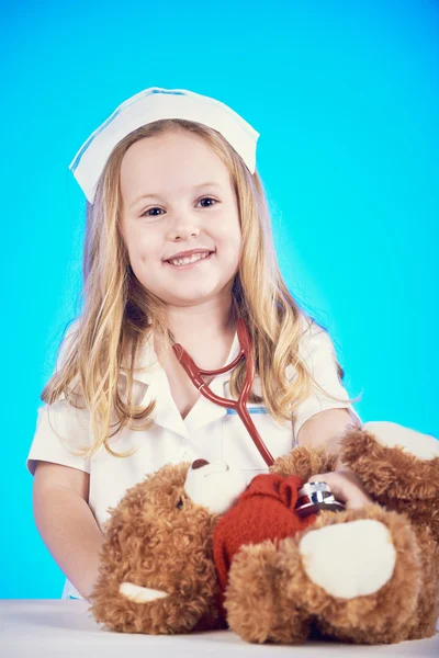 Beautiful nurse examiner little sick brown teddy bear.