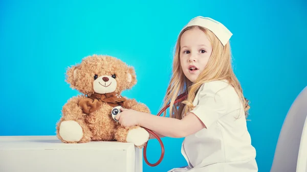 Beautiful nurse examiner little sick brown teddy bear.