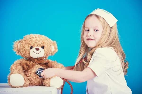 Beautiful nurse examiner little sick brown teddy bear.