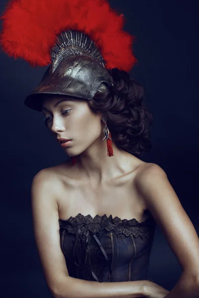 Woman in helmet with red feathers