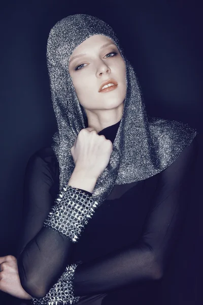 Woman in head wear and bracelets with spikes