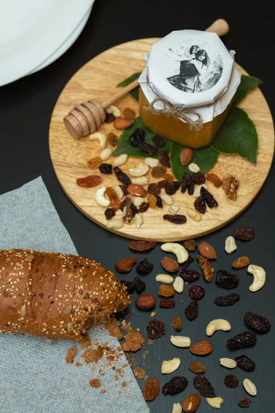 Bee honey with nuts with cookie top view on wooden table background with some blur