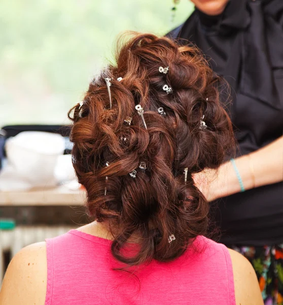 Back of woman with hair curlers and hairpins