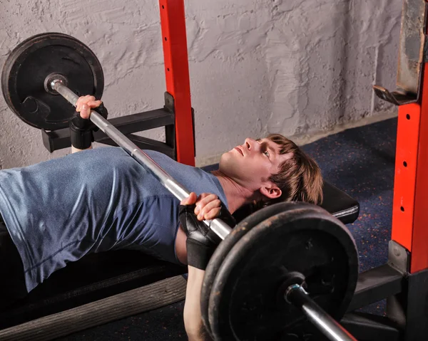 Man doing bench press with a barbell.