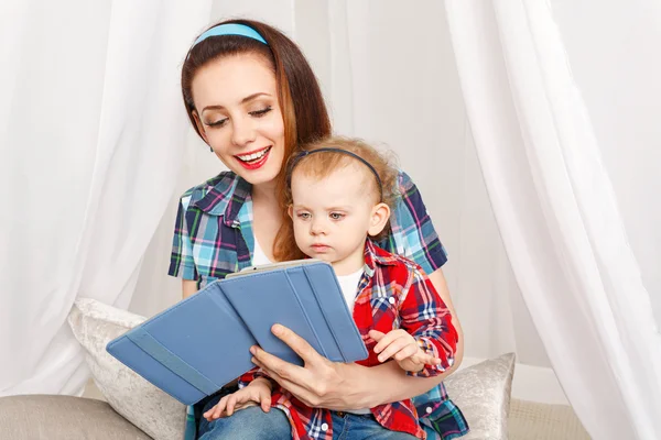 Mother and little daughter reading ebook