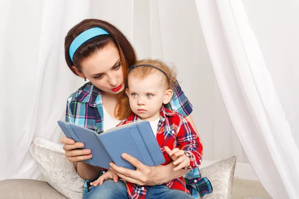 Mother and little daughter read ebook