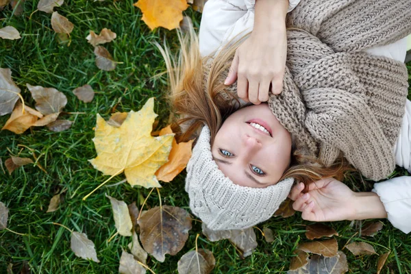 Girl lying on the fallen leaves. Autumn.