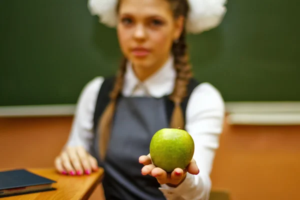 Excellent student holding a green apple.
