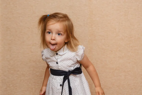 Little girl shows tongue. Emotional child.