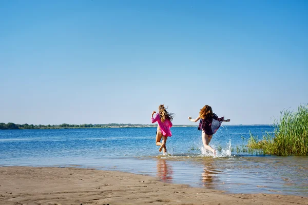 Best friends running to swim in river.