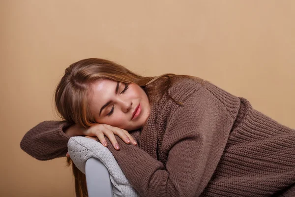 Girl in a warm sweater fell asleep.