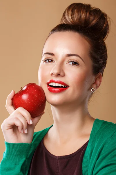 Girl with a clean skin holding a red apple.