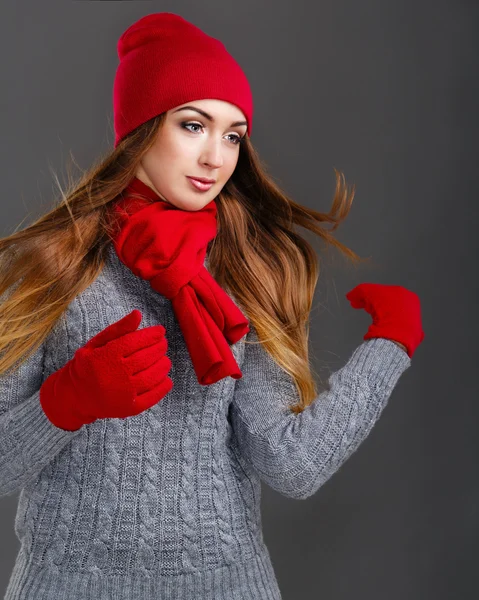 Girl in knit sweaters, gloves and hats.