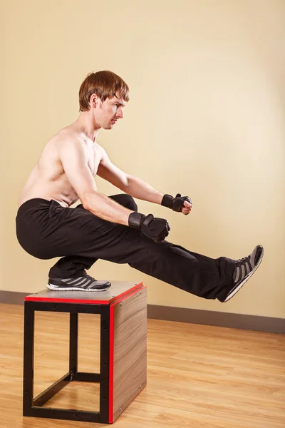 Man doing squats on one leg.