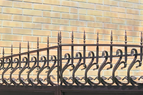 Forged fence on gate against a wall