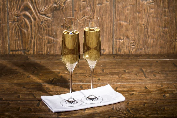 Two beautiful glasses of champagne are standing on a white napki