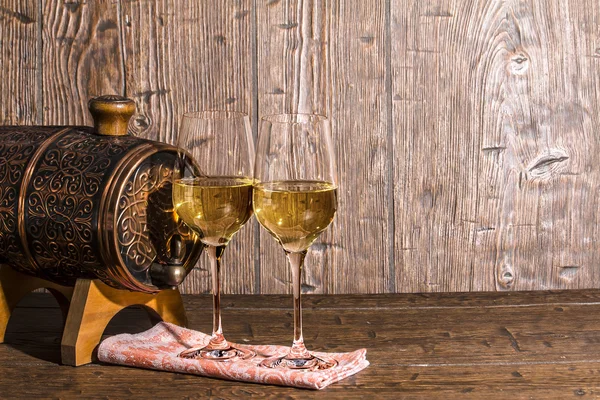 Copper forged barrel and a two glass of wine are stand on a old