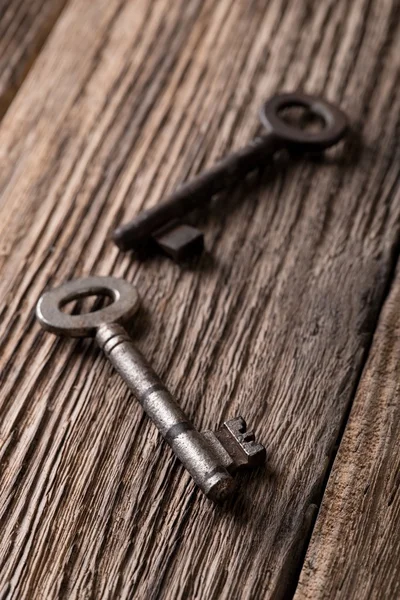 Two old keys on old worn wooden board