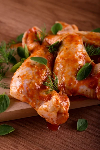 Several marinated chicken wings with green herbs