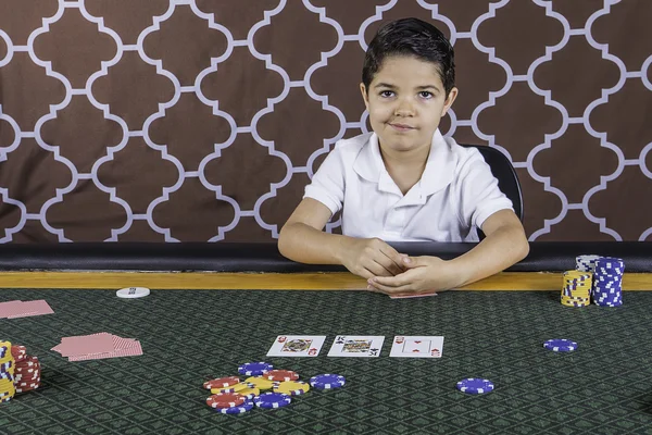 A young boy playing poker at a table