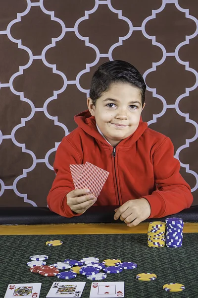 A young boy playing poker at a table
