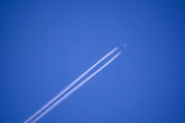 Plane flying on a perfectly blue sky with vapor trail