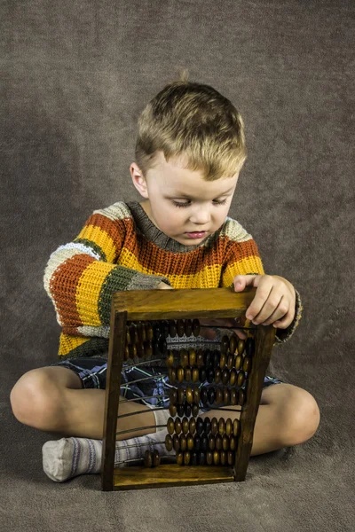 Boy learning to count on wooden accounts