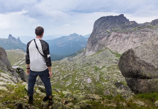Man on the top of  hill watching wonderful scenery in mountains during summer