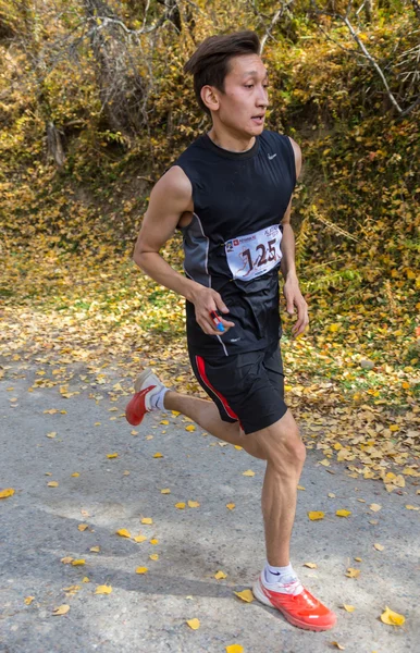 ALMATY,ALMATY DISTRICT, KAZAKHSTAN-OCTOBER 10, 2015: Man runs for fun and take part in a sporting event, on the competition trail running Alatau Train Run 2016, in the national reserve Yunats Lakes