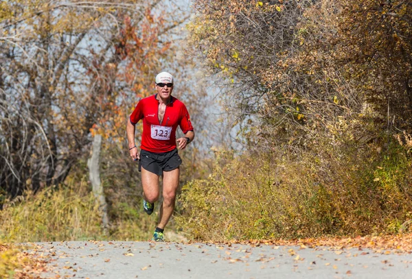 ALMATY,ALMATY DISTRICT, KAZAKHSTAN-OCTOBER 10, 2015: Man runs for fun and take part in a sporting event, on the competition trail running Alatau Train Run 2016, in the national reserve Yunats Lakes