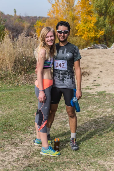 ALMATY,ALMATY DISTRICT, KAZAKHSTAN-OCTOBER 10, 2015: Beautiful couple participates in competitions in running, on the competition trail running Alatau Train Run 2016, in the national reserve Yunats