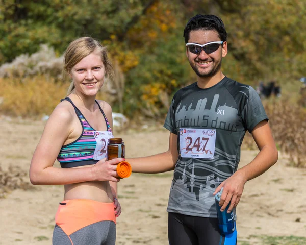 ALMATY,ALMATY DISTRICT, KAZAKHSTAN-OCTOBER 10, 2015: Beautiful couple participates in competitions in running, on the competition trail running Alatau Train Run 2016, in the national reserve Yunats