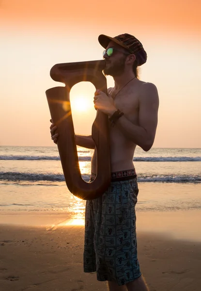 Dj playing summer hits at sunset beach party with trumpet jazz performer