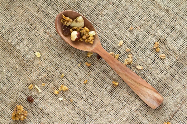 Muesli in wooden spoon on canvas tablecloth